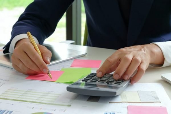 analysts-use-a-calculator-and-pen-to-evaluate-the-fluctuating-stock-market-situation--740x468